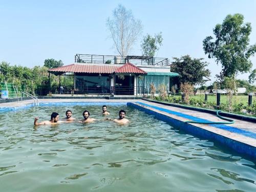a group of children swimming in a swimming pool at The River Side Resort & Farm in Noida
