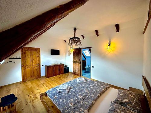 a bedroom with a bed and a chandelier at Casa de Lemn Arpasu de jos in Arpaşu de Jos