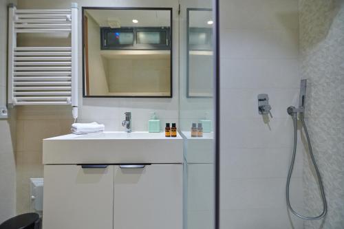 a white bathroom with a sink and a shower at Apartment Sea View B2 - Mosquée Hassan II - By TheCasaEdition in Casablanca