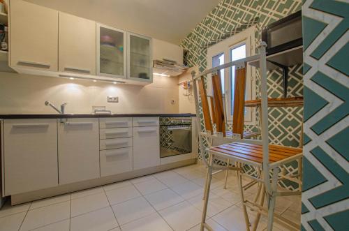 eine Küche mit weißen Schränken und einem Holzstuhl in der Unterkunft La met au loup in Charmont-sous-Barbuise
