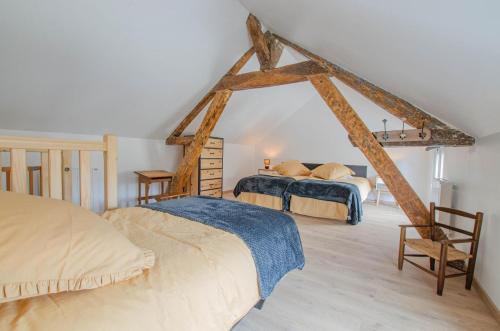 een slaapkamer met 2 bedden op een zolder bij Le paco in Bar-sur-Aube