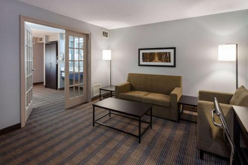 a living room with a couch and a table at AmericInn by Wyndham Peoria in Peoria