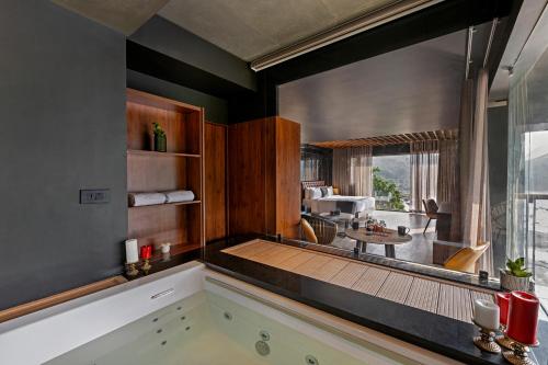 a bathroom with a large window and a bath tub at Sterling Athirappilly in Kallana