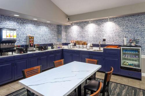 a kitchen with blue cabinets and a white table at AmericInn by Wyndham Peoria in Peoria