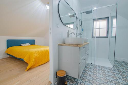 a bathroom with a bed and a sink and a mirror at Au naturel in Montreuil-sur-Barse