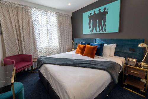 Habitación de hotel con cama grande con almohadas de color naranja en TRYP by Wyndham Wellington, Tory Street, en Wellington