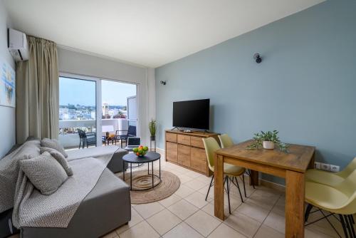 a living room with a couch and a table and a television at Elli Beach Downtown Apartments in Rhodes Town