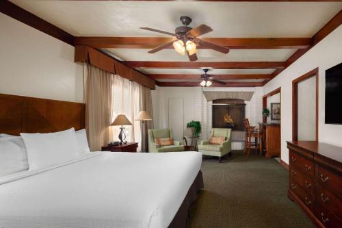 Coronado Motor Hotel, a Travelodge by Wyndham في يوما: غرفة نوم بسرير ومروحة سقف