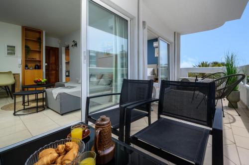 a balcony with two chairs and a basket of bread at Elli Beach Downtown Apartments in Rhodes Town