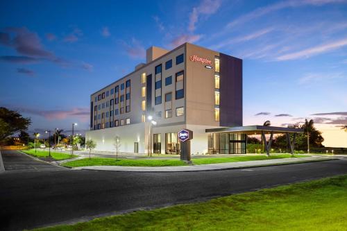 een groot gebouw aan de straatkant bij Hampton By Hilton Guanacaste Airport in Liberia