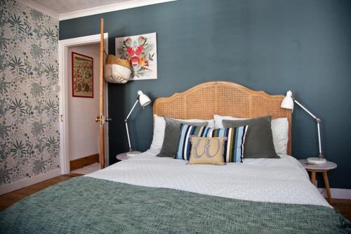 a bedroom with a large bed with blue walls at Whitstable Cottage - Perfect Location in Whitstable