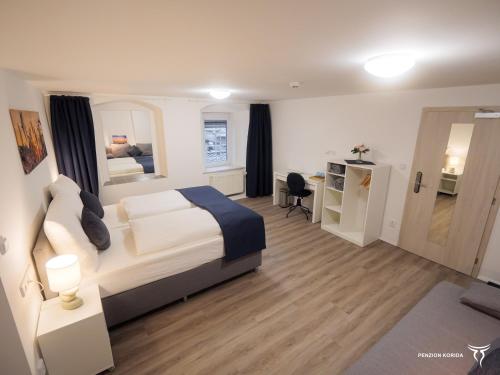 a hotel room with a bed and a desk and a room at Penzion Korida in Ústí nad Labem