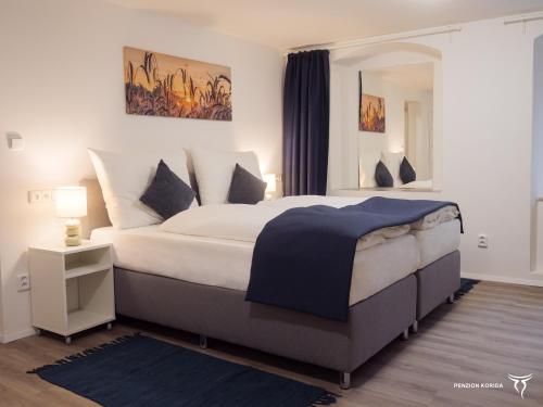 1 dormitorio con 1 cama grande y espejo en Penzion Korida, en Ústí nad Labem