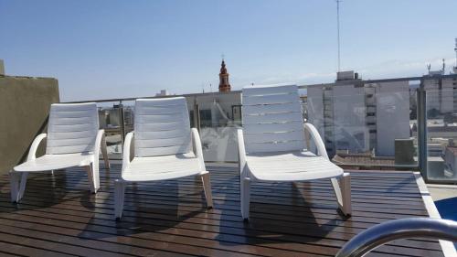 three white chairs sitting on top of a roof at Departamento Caseros Desing in Salta