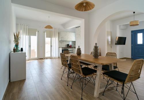 a kitchen and dining room with a wooden table and chairs at La maison in Parikia