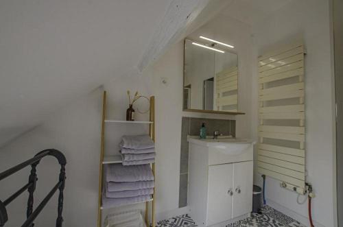 ein Badezimmer mit einem Waschbecken, einem Spiegel und Handtüchern in der Unterkunft Chez pat & fred in Balnot-la-Grange