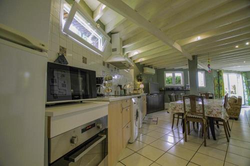 une cuisine et une salle à manger avec une table et des chaises dans l'établissement Au chant du coq, à Saint-Lyé