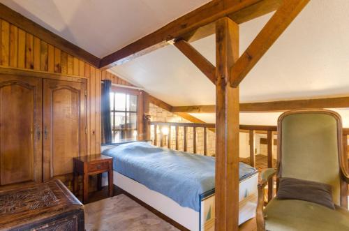 a bedroom with a bed in a room with wooden walls at La sablonniere in La Ville-aux-Bois