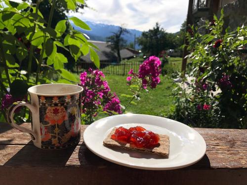 a piece of bread with fruit on a plate next to a cup at Guest House Keti Margiani Mestia in Mestia