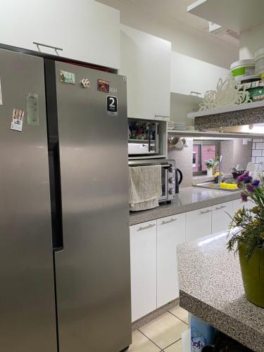 a stainless steel refrigerator in a kitchen with white cabinets at Casa Elias Hostel-Av Elias in Valparaíso