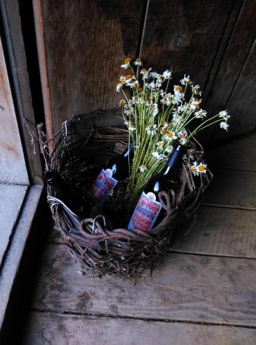 a basket of wine bottles and flowers on the ground at Guest House Keti Margiani Mestia in Mestia