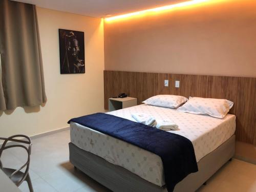 1 dormitorio con 1 cama grande con manta azul en Premium Hotel, en Delmiro Gouveia