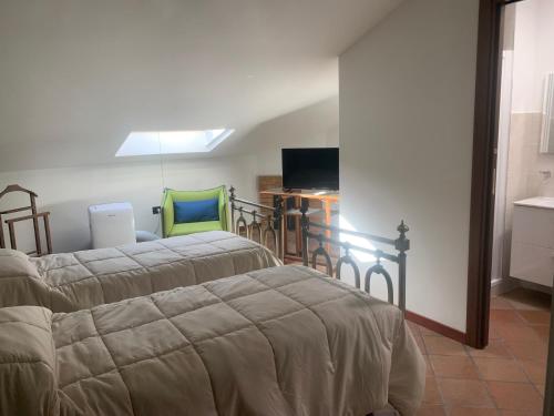 a bedroom with two beds and a television in it at Guest house Il Palazzo Marchesale in Carife