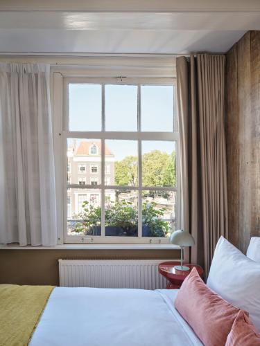 a bedroom with a bed and a large window at Max Brown Hotel Canal District, part of Sircle Collection in Amsterdam