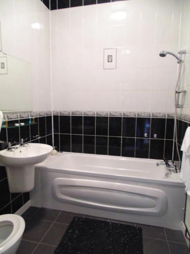 e bagno con vasca, servizi igienici e lavandino. di 39 Sri Gandha a New Bedfont