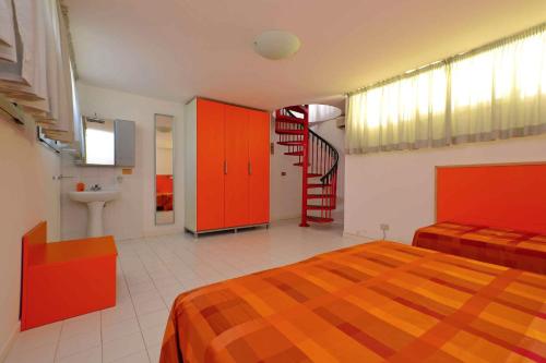 a bedroom with red cabinets and a staircase at Apartments in Lignano 21597 in Lignano Sabbiadoro