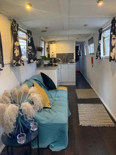 a living room with a blue couch and a table at Narrow Boat moored in London in London