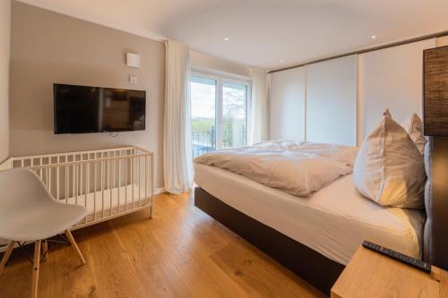 a bedroom with a bed and a tv on a wall at Villa "Haus am Meer" in Dahme