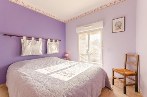 a bedroom with purple walls and a bed and a chair at La ferme des chartreux in Messon
