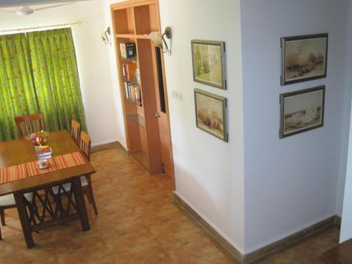 uma sala de jantar com uma mesa e cadeiras e uma parede em Boutique Villa, beach 10min, cook on request em Betalbatim
