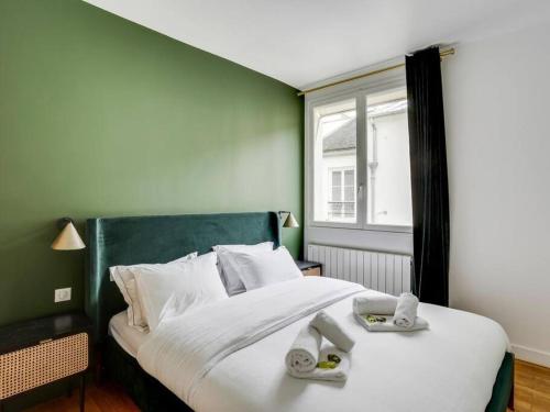 une chambre avec un grand lit avec deux serviettes dessus dans l'établissement Amazing Apartment: 2BR/4P -Bastille/Saint Ambroise, à Paris