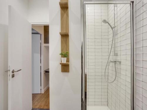une salle de bain avec douche carrelée de blanc dans l'établissement Amazing Apartment: 2BR/4P -Bastille/Saint Ambroise, à Paris