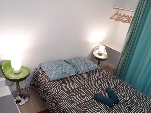 a small bedroom with a bed with two blue pillows at appartement 2 pieces ,paris proche in Saint-Ouen