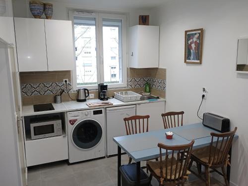 a kitchen with a table and a washing machine at appartement 2 pieces ,paris proche in Saint-Ouen