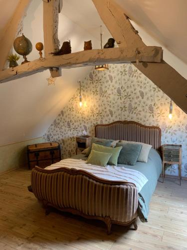 une chambre avec un grand lit dans un grenier dans l'établissement Bocage et Coquillage, à Gouville-sur-Mer