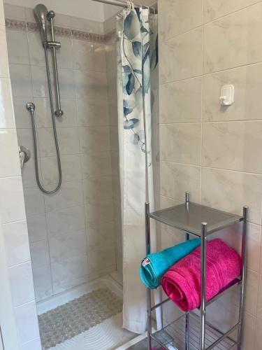 La salle de bains est pourvue d'une douche, d'une serviette rose et d'une table. dans l'établissement Appartement 2 pièces-4 personnes, à Roquebrune-Cap-Martin