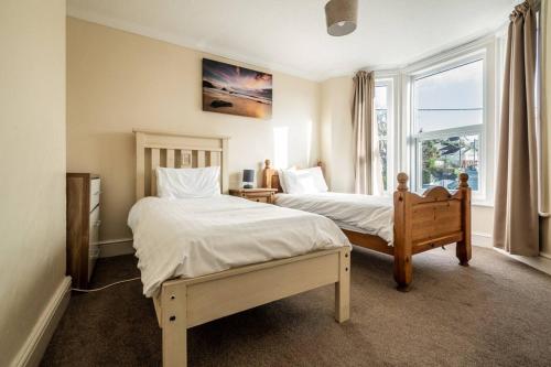 a bedroom with two beds and a window at Pass the Keys Cosy quirky home in seaside town sleeps 4 in Exeter