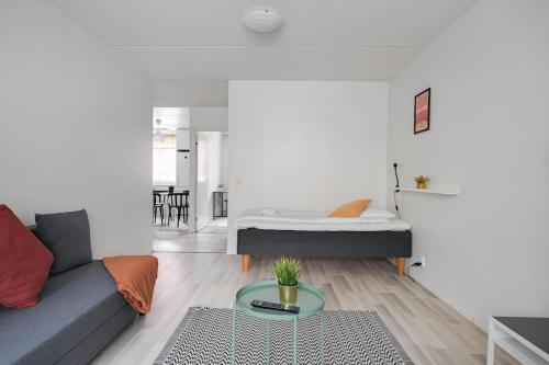 ein Wohnzimmer mit einem Sofa und einem Bett in der Unterkunft Kotimaailma- Valoisa kaksio jopa viidelle in Helsinki