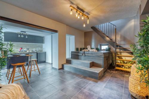 een woonkamer met een trap en een keuken bij 50 Nuances d'Amour - Jacuzzi / Massage / Cinéma in Moirans
