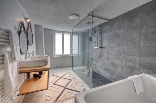 een badkamer met een bad, een wastafel en een douche bij 50 Nuances d'Amour - Jacuzzi / Massage / Cinéma in Moirans