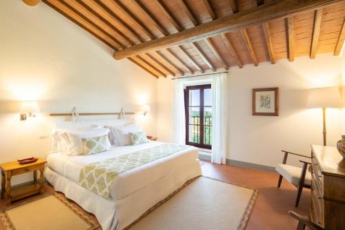 a bedroom with a white bed and a window at The Club House in Castelnuovo Berardenga