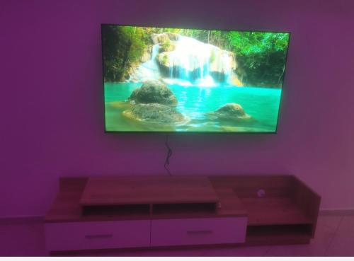 a living room with a tv on a purple wall at Bijoux Harhoura in El Harhoura