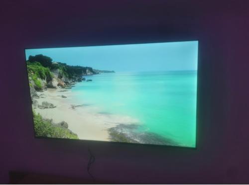 einen TV-Bildschirm mit einem Bild eines Strandes in der Unterkunft Bijoux Harhoura in El Harhoura