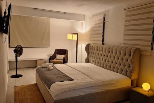 a bedroom with a large bed and a chair at White Bliss in Terre Rouge