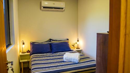 um pequeno quarto com uma cama com almofadas azuis em Container Lodge SB em San Bernardino
