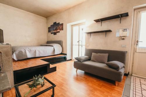1 dormitorio con 1 cama y 1 sofá en una habitación en Appartamento Flaminia - Affitti Brevi Italia, en Varese